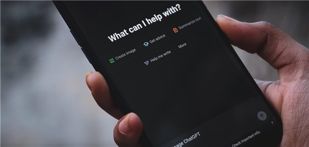 Person hält Smartphone welches eine ChatGPT-Anwendungsschnittstelle anzeigt.